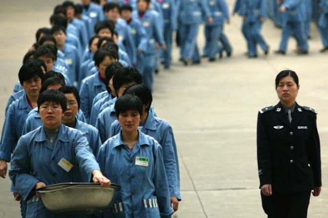 Prisoners walk beside a police escort during a prison open day in Nanjing, 2005. 
