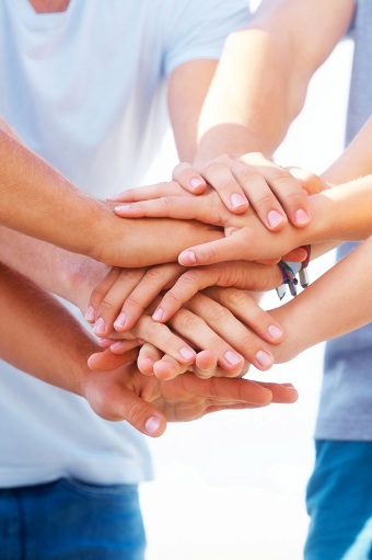 Closeup of a young group with their hands stacked together, focus on the hands