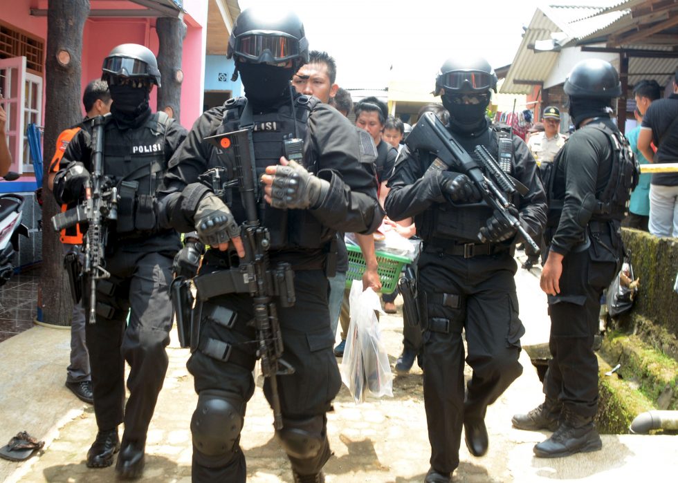 Armed anti-terror police walk ahead of guard officers carrying bags of evidence from the house of a man suspected of being involved in Islamic State-related activities in south Tangerang, Indonesia's Banten province, March 22, 2015 in this photo taken by Antara Foto.  REUTERS/Antara Foto/Muhammad Iqbal  ATTENTION EDITORS - THIS IMAGE HAS BEEN SUPPLIED BY A THIRD PARTY. IT IS DISTRIBUTED, EXACTLY AS RECEIVED BY REUTERS, AS A SERVICE TO CLIENTS. MANDATORY CREDIT. INDONESIA OUT. NO COMMERCIAL OR EDITORIAL SALES IN INDONESIA. FOR EDITORIAL USE ONLY. NOT FOR SALE FOR MARKETING OR ADVERTISING CAMPAIGNS. - RTR4UDIF