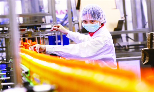 A worker checks bottled Sunquick brand juice on a production line of the new CO-RO FOOD 